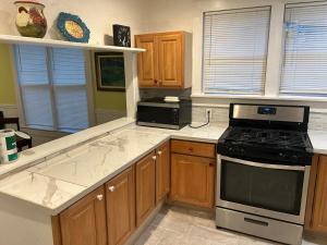 a kitchen with wooden cabinets and a stove top oven at 2br 2ba Close to Downtown, Midtown, and FSU in Tallahassee +9 photos