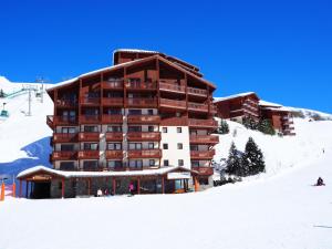 een groot gebouw op een skipiste in de sneeuw bij Résidence Valmonts A - Appartement duplex rénové · Départ ski aux pieds · Balcon MAE-9904 in Les Bruyères +16 foto's