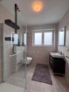 a bathroom with a shower and a sink and a toilet at Ferienwohnung NOVA 1 Merzig - Brotdorf in Merzig