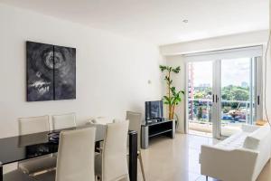 a living room with a dining room table and white chairs at Arenas del Mar Apartments in Punta del Este
