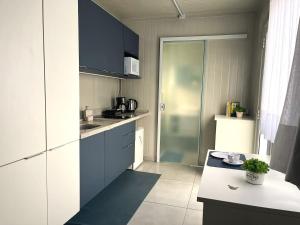 a small kitchen with blue cabinets and a counter at Estudio Vila dos Pescadores in São Francisco do Sul +20 photos