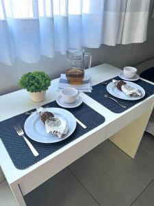 a table with two plates and a pitcher of tea at Estudio Vila dos Pescadores in São Francisco do Sul
