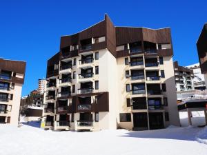 ein Apartmenthaus im Schnee mit blauem Himmel in der Unterkunft Résidence Soldanelles A - Deux pièces 4 pers clois 28 m² balcon SUD OUEST MAE-1264 in Les Menuires