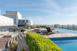 a swimming pool on the roof of a building at Hom Nilo Home by LikeHome in Porto Alegre