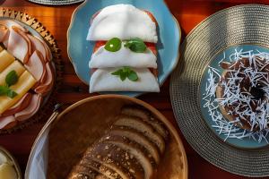 ein Tisch mit Tellern voller Essen und Brot in der Unterkunft Villa Toucan in Itacaré + 70 Fotos