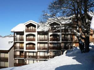 a snow covered building with a tree in front of it at Résidence Murgers - Appartement lumineux · A proximité des pistes · Balcon MAE-3004 in Saint-Martin-de-Belleville