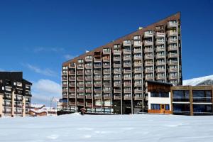 un grande edificio con la neve davanti di Résidence Grande Masse - Studio lumineux · Départ et retour skis aux pieds · Balcon MAE-3354 a Les Menuires