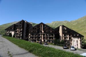 una fila di condomini con montagne sullo sfondo di Résidence Sarvan - Appartement · Balcon · Quartier Preyrand · Pied des pistes MAE-4594 a Les Menuires