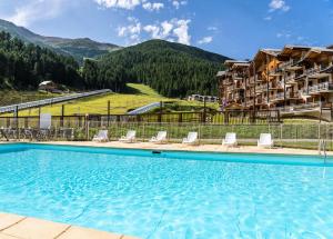 a pool at a hotel with mountains in the background at Résidence Les Hauts De Preclaux - Studio rénové au coeur des Orres 1800 MAE-6234 in Les Orres
