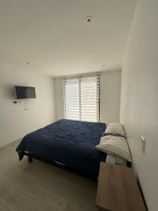 a bedroom with a blue bed and a window at casa mediterranea in Calera de Tango