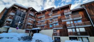 an apartment building with snow in front of it at Résidence Hameaux Ii - Studio rénové 3 personnes - Plagne Village MAE-7324 in Aime La Plagne