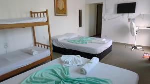 a room with two bunk beds and a flat screen tv at PORTO SUÍTES PERUÍBE CHECK-OUT LIVRE aos DOMINGOS in Peruíbe +16 photos