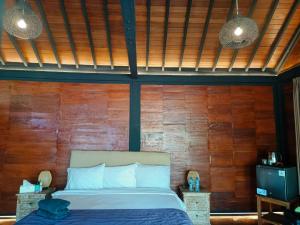 una camera da letto con un letto e una parete di legno di Villa Ssweta 2 a Canggu Altre 21 foto