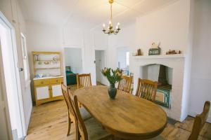 a dining room with a table and chairs and a fireplace at The Orchard Farm in Tallong