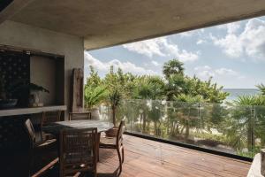 a dining room with a view of the ocean at Beachfront 3BR Condo with Private Rooftop and lounge pool, Tankah Bay in Tulum