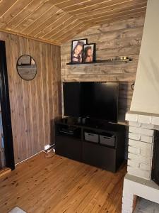 a living room with a flat screen tv on a wall at Cabin in Silisjávri in Skillemo