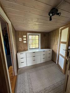 a small room with a white cabinet and a window at Cabin in Silisjávri in Skillemo