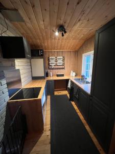 a small kitchen with a counter and a sink at Cabin in Silisjávri in Skillemo +6 photos