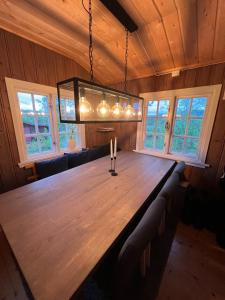 a large wooden table in a room with windows at Cabin in Silisjávri in Skillemo