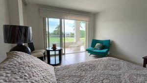 a bedroom with a bed and a chair and a window at Space, style, and serenity in Jarretadera +22 photos