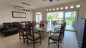 a dining room with a glass table and chairs at Space, style, and serenity in Jarretadera