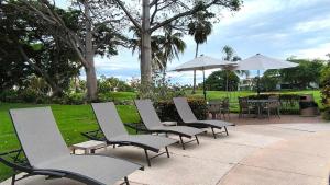 a row of lawn chairs and tables with umbrellas at Space, style, and serenity in Jarretadera