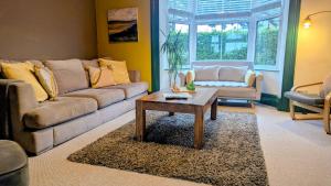 a living room with a couch and a coffee table at Family Home in Tywyn - Game and Cinema Rooms in Tywyn