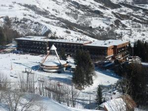 un grande edificio nella neve vicino a una montagna di Résidence Agena - STUDIO CABINE 4 PERSONNES SUR FRONT DE NEIGE MAE-9061 a Villarembert