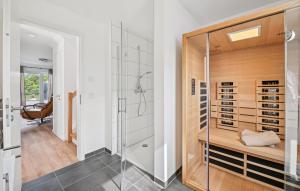 ein Bad mit einer ebenerdigen Dusche und einer Duschkabine aus Glas in der Unterkunft Thor in Tossenserdeich