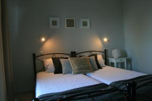 a bedroom with a bed with white sheets and pillows at Vasilina in Faliraki