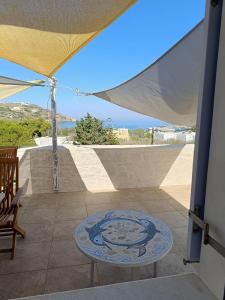 a patio with a table and an umbrella at Mosaic house by the sea in Kini +12 photos