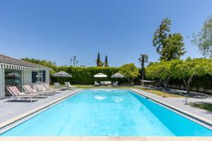 a swimming pool with chairs and a house at Thanks for the Memory by ACME House Company in Palm Springs