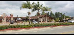 una strada con un edificio e palme e una strada di aparta hotel campestre luxury en llanogrande 10 minutos aeropuerto a Rionegro