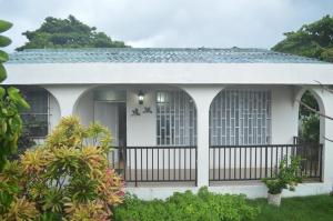 una pequeña casa blanca con una valla negra en Posada Henry en San Andrés