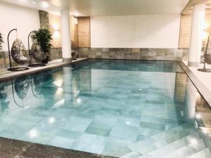 ティーニュにあるRésidence Lodge Des Neiges C - Appartement 4 - pied de pistes, service hotelier inclus MAE-6751のブルータイルフロアのスイミングプール