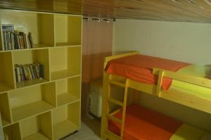 een slaapkamer met een stapelbed en boekenplanken bij Posada Henry in San Andrés