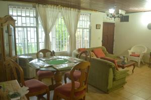 uma sala de estar com um sofá, uma mesa e cadeiras em Posada Henry em San Andrés