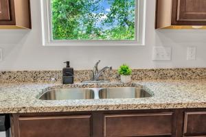 eine Küchenspüle mit einem Fenster darüber in der Unterkunft Upscale King 3BR Townhouse Mins to Cary & NC State in Raleigh + 39 Fotos