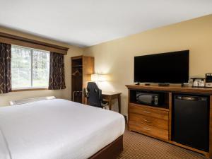 a hotel room with a bed and a flat screen tv at Country Inn Two Harbors in Two Harbors