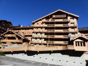a tall building with balconies on the side of it at Résidence La Suite - Magnifique appartement 3 pièces cabine situé à Méribel centre proche des commerces et des pistes de ski MAE-6403 in Les Allues