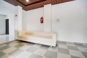 a white couch in a room with a checkered floor at Super Collection O Omkar Nagar Nagpur in Nagpur
