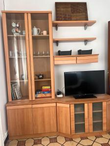 a wooden entertainment center with a flat screen tv at Casa das Pasadiñas-Burela in Burela de Cabo +20 photos
