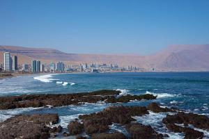 a beach with rocks and a city in the background at DEPARTAMENTO NEO dos dormitorios con vista al mar in Iquique +9 photos