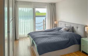 a bedroom with a bed and a large window at 3 Bedroom Amazing Home In Workum in Workum
