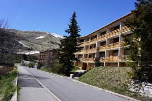 an empty road in front of a building at Résidence Roches Rousses B - studio box 5/6 personnes MAE-2776 in Orcières