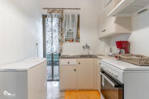 a kitchen with white cabinets and a sink at Nefeli - Unique Beachfront Apartment in Nea Makri +39 photos
