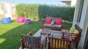 two benches with colorful pillows sitting on a porch at Azha Sokhna private villa in Ain Sokhna
