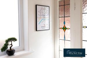 a picture hanging on a wall next to a door with a plant at Stylish 5 bed home in Beeston in Nottingham
