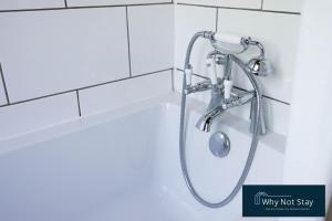 a shower in a bathroom with a shower head at Stylish 5 bed home in Beeston in Nottingham +13 photos