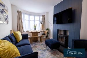 a living room with a blue couch and a table at Stylish 5 bed home in Beeston in Nottingham